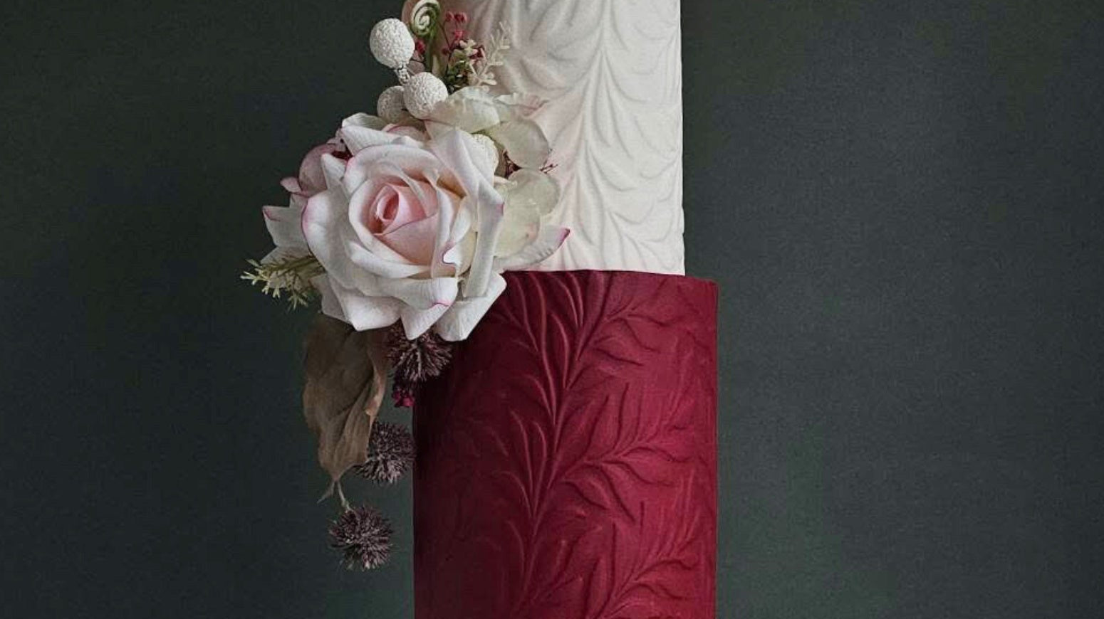 Textured wedding cake covered in a pressed Full Bloom floral pattern by Dee-vine Cakes